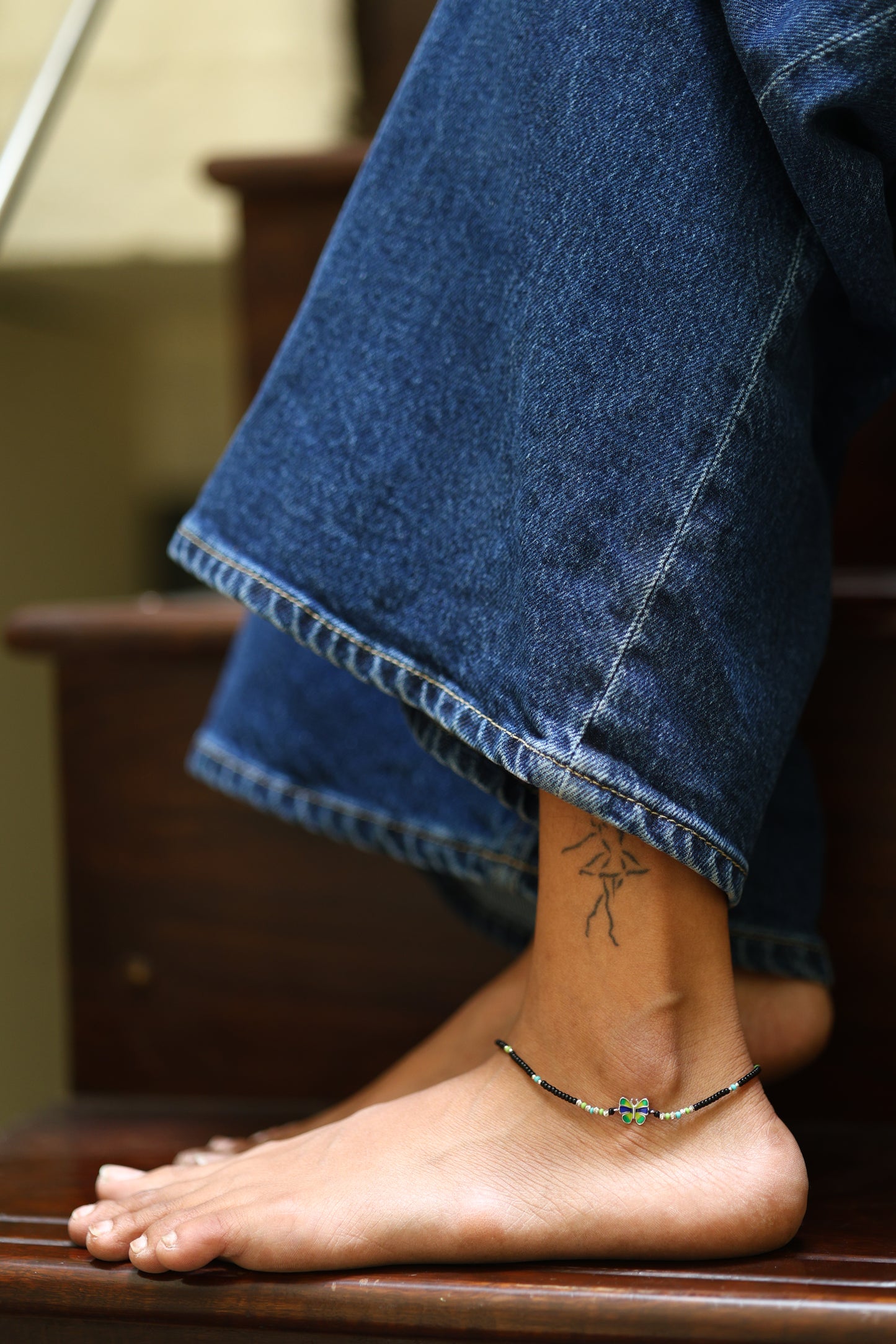 Black beaded with a colorful butterfly charm Silver Anklet.