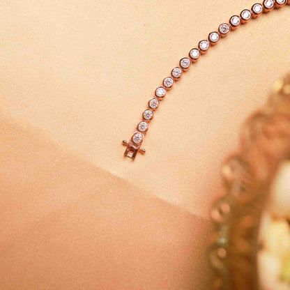 Rose gold bracelet with diamonds on a beige background