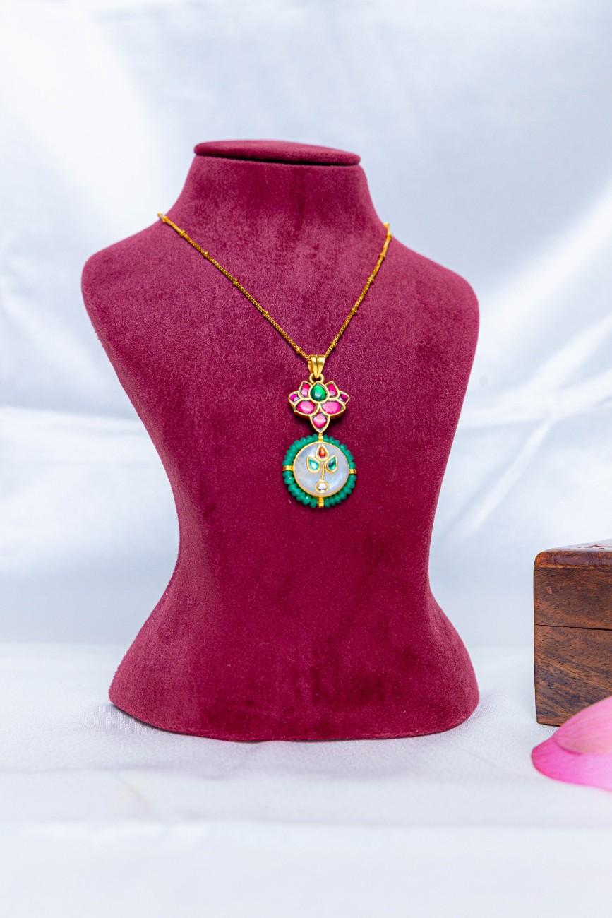 Gold-tone 92.5 silver necklace with a pink enamel lotus pendant, circular motif, and green stone detailing.