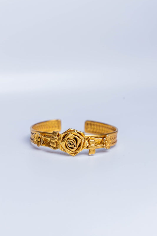 Traditional gold-tone gadi bangle with intricate floral carvings and a prominent rose motif.