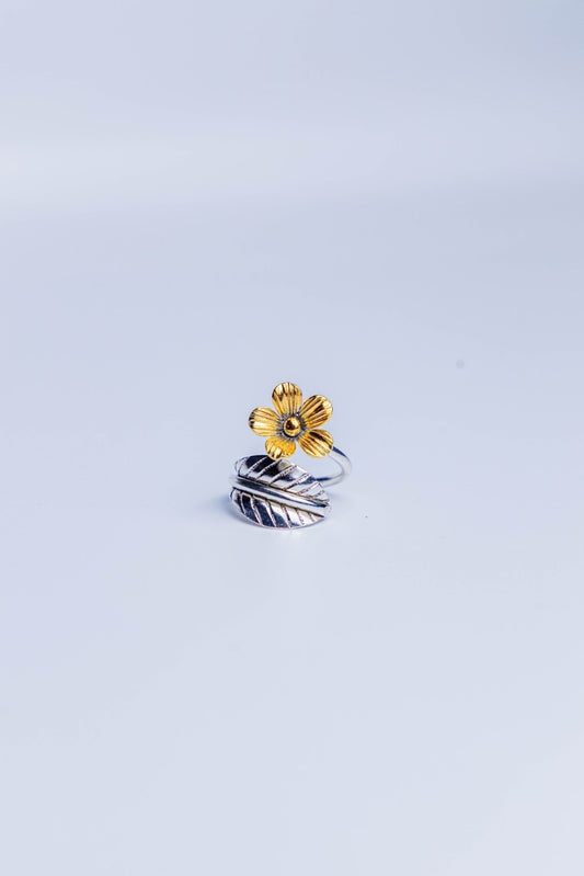 Dual-tone adjustable ring with a gold flower and silver leaf motif.