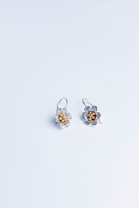 Handcrafted dual tone floral silver earrings with gold bead detailing.