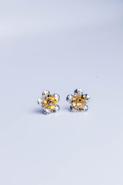 Handcrafted dual-tone sterling silver stud earrings featuring hammered petal design with gold-accented floral center.