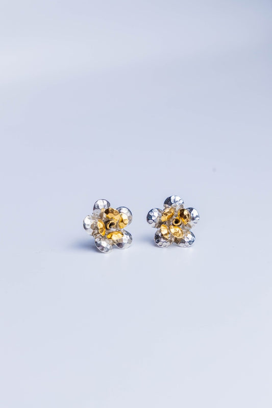 Handcrafted dual-tone sterling silver stud earrings featuring hammered petal design with gold-accented floral center.