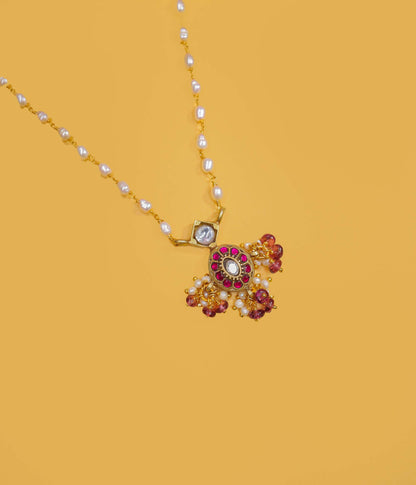 Gold plated pearl beaded necklace with a ruby-toned pendant and pearl clusters in 92.5 sterling silver.