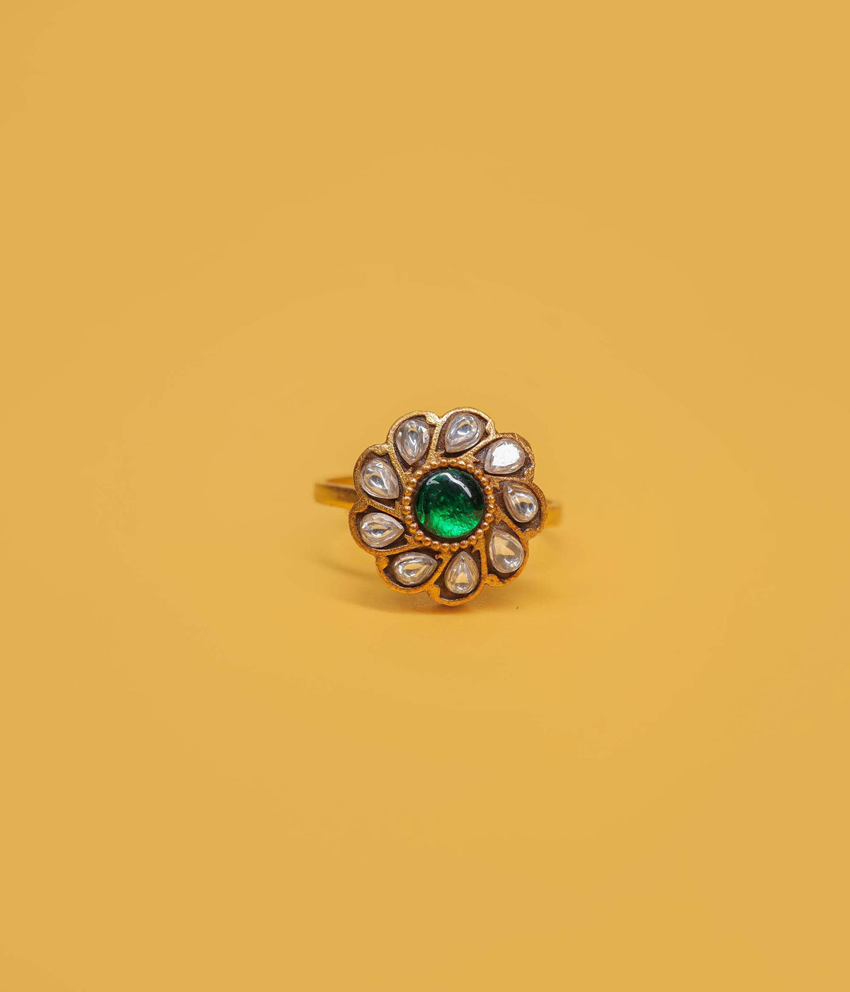 Emerald bloom gold plated ring in 92.5 sterling silver with green centre stone and white kundan floral design.