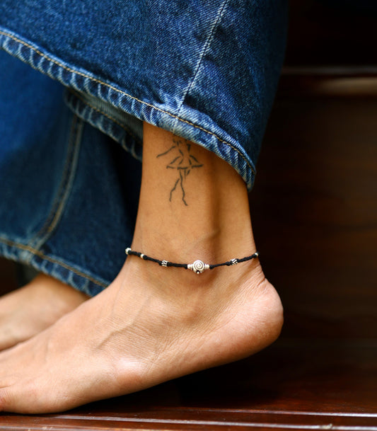 Handcrafted black thread anklet with tribal-style silver bead.