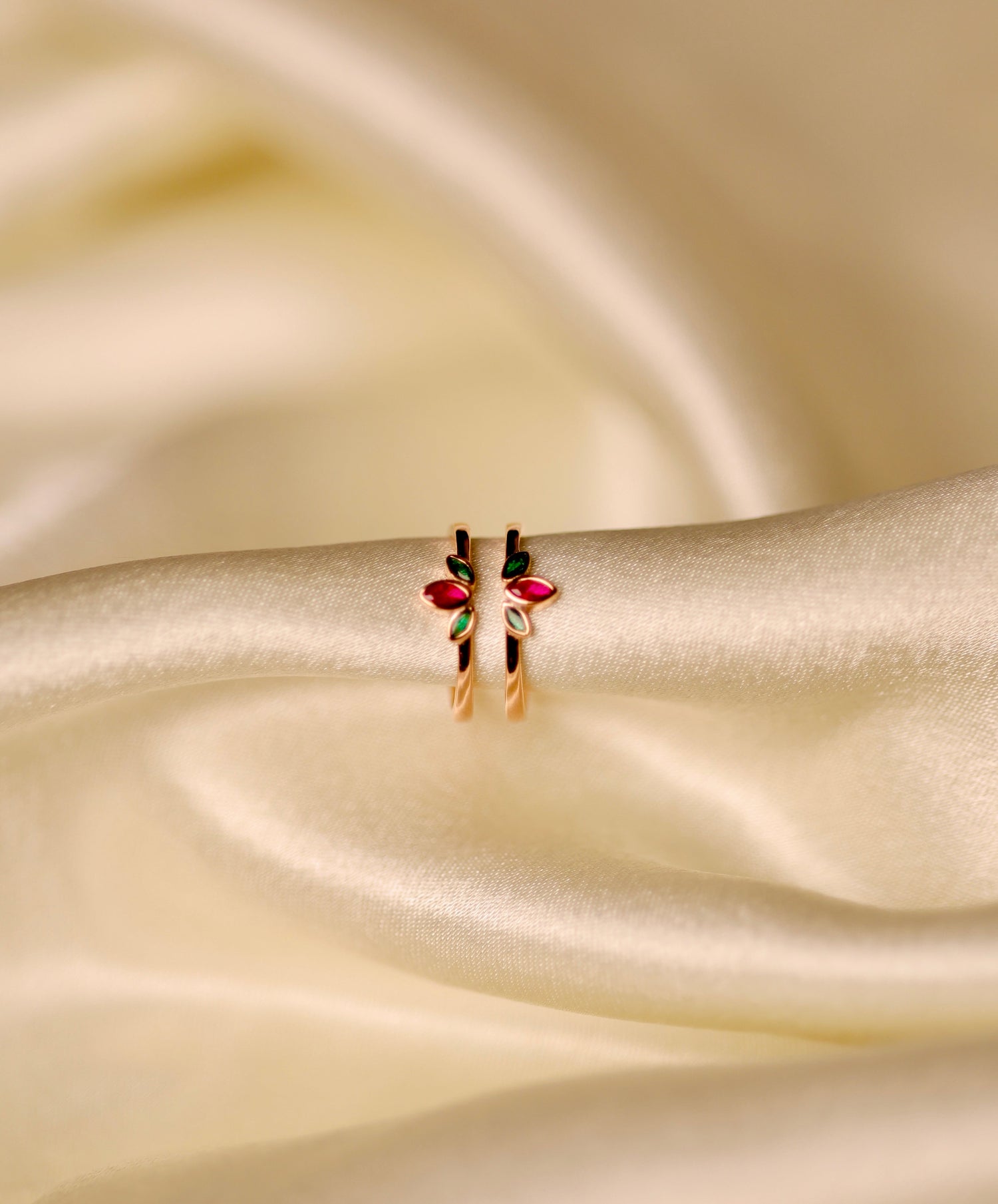 Rose gold dual band ring with ruby and emerald leaf gemstones.
