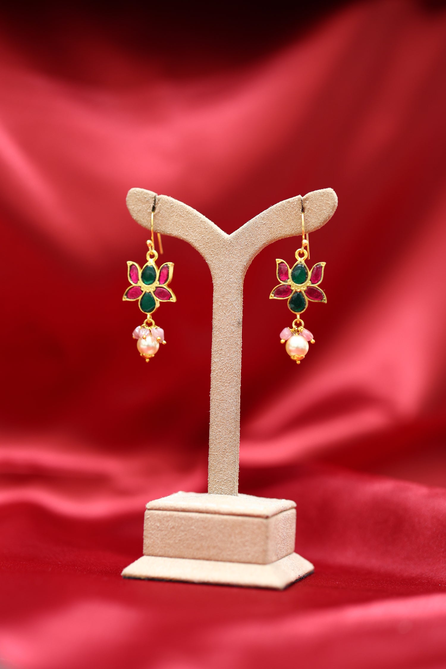 Lotus design gold-plated earrings with ruby and emerald stones and pearl drops.