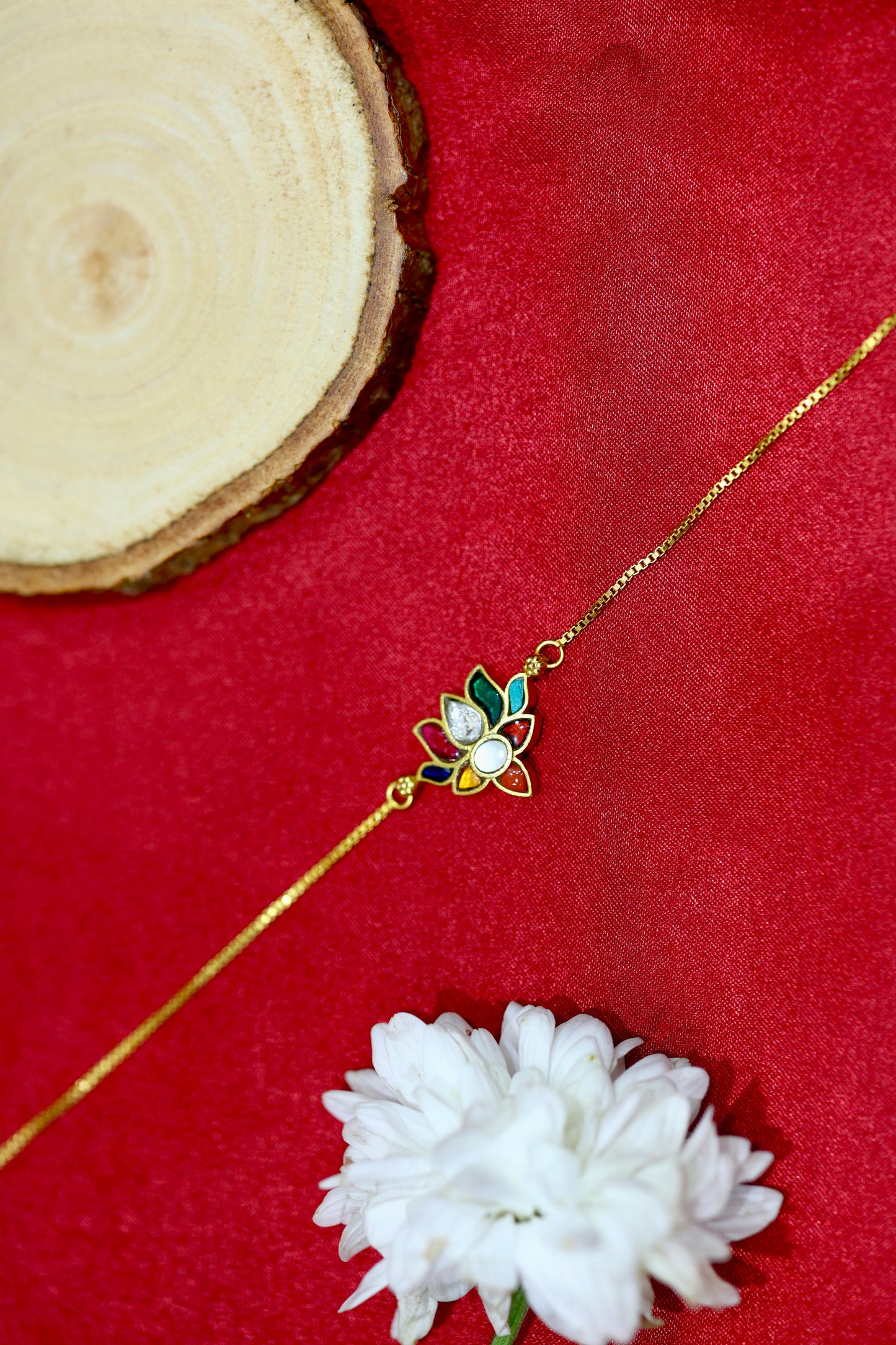 Gold-plated bracelet with a lotus charm made of multicolored petals and kundan stones.