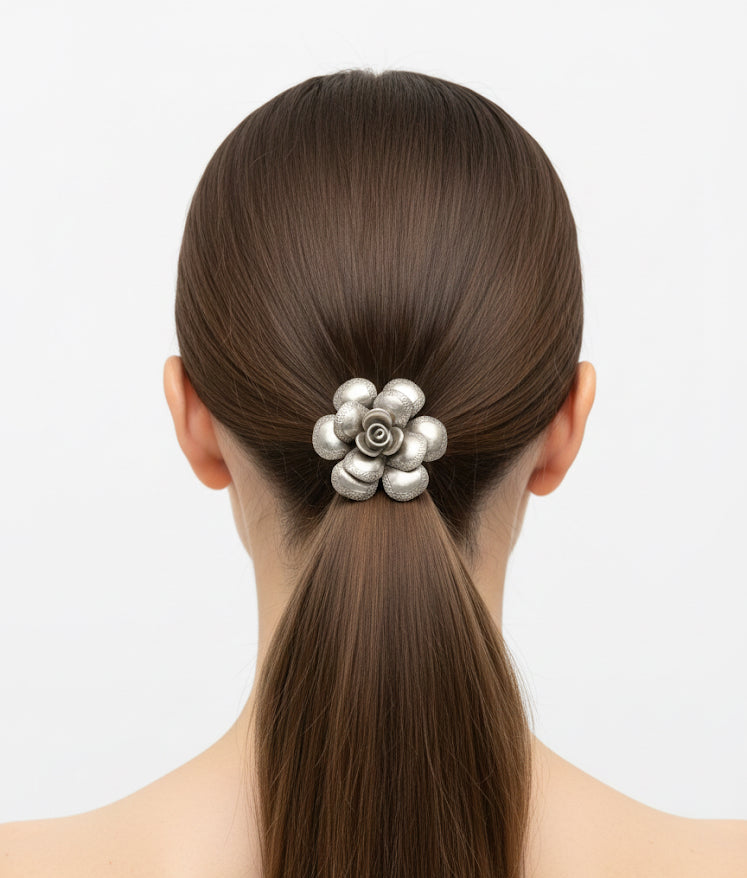 Woman with a high ponytail wearing a decorative hair clip on a plain background