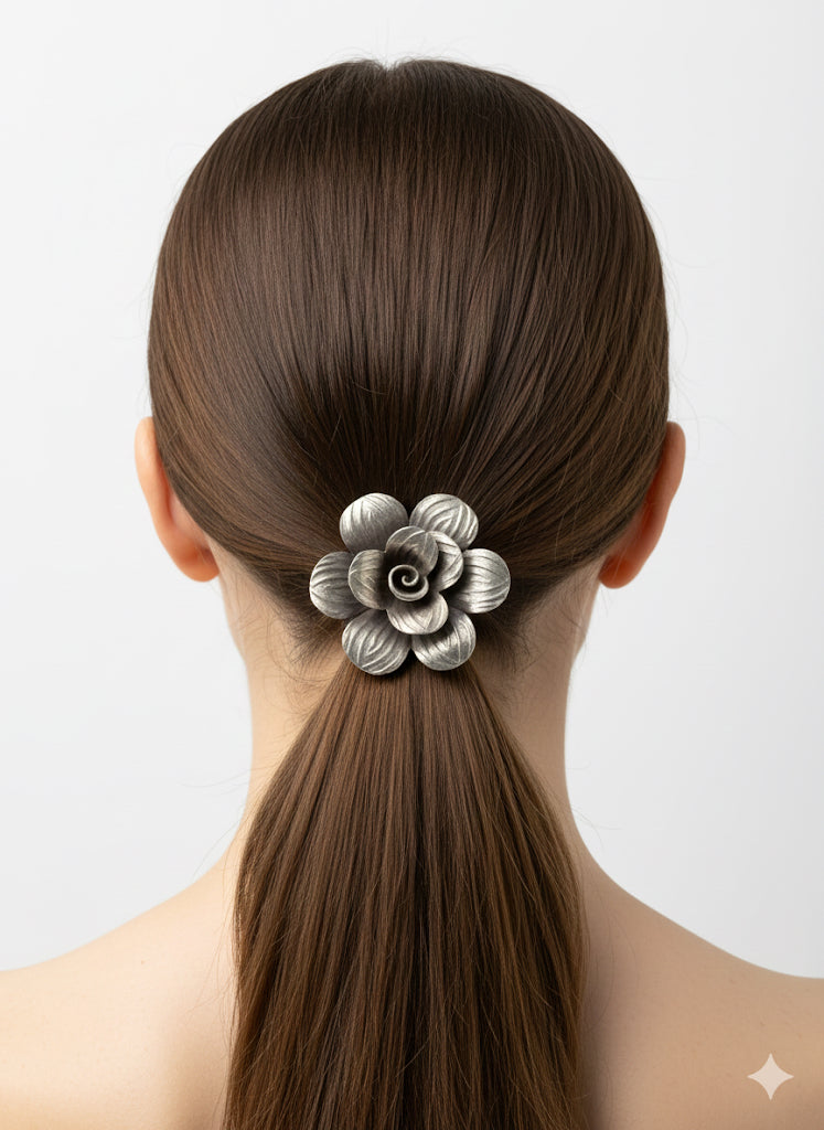 Woman with a ponytail holding a decorative hair clip against a light background