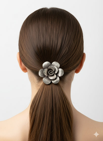 Woman with a ponytail holding a decorative hair clip against a light background