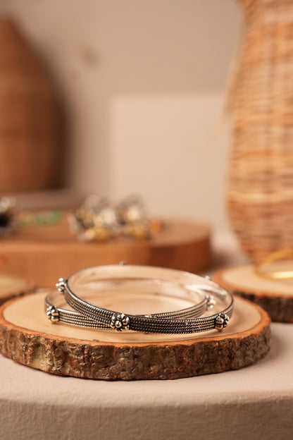 Handcrafted oxidised silver bangles with floral design.