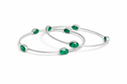 Sterling silver bangle with faceted emerald green stones.