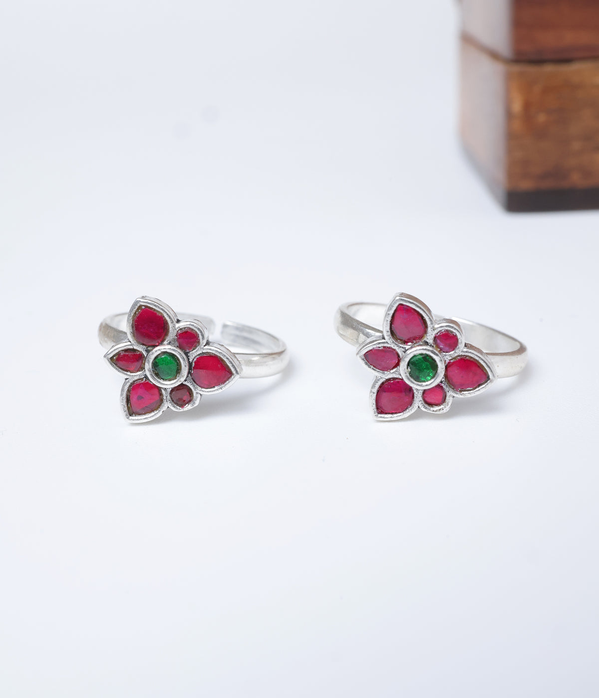 92.5 sterling silver floral toe ring with ruby-red petals and emerald-green centre stone.