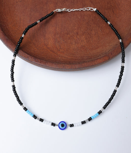 Black beaded anklet with a blue evil eye charm, white and turquoise bead accents, and silver-tone detailing.