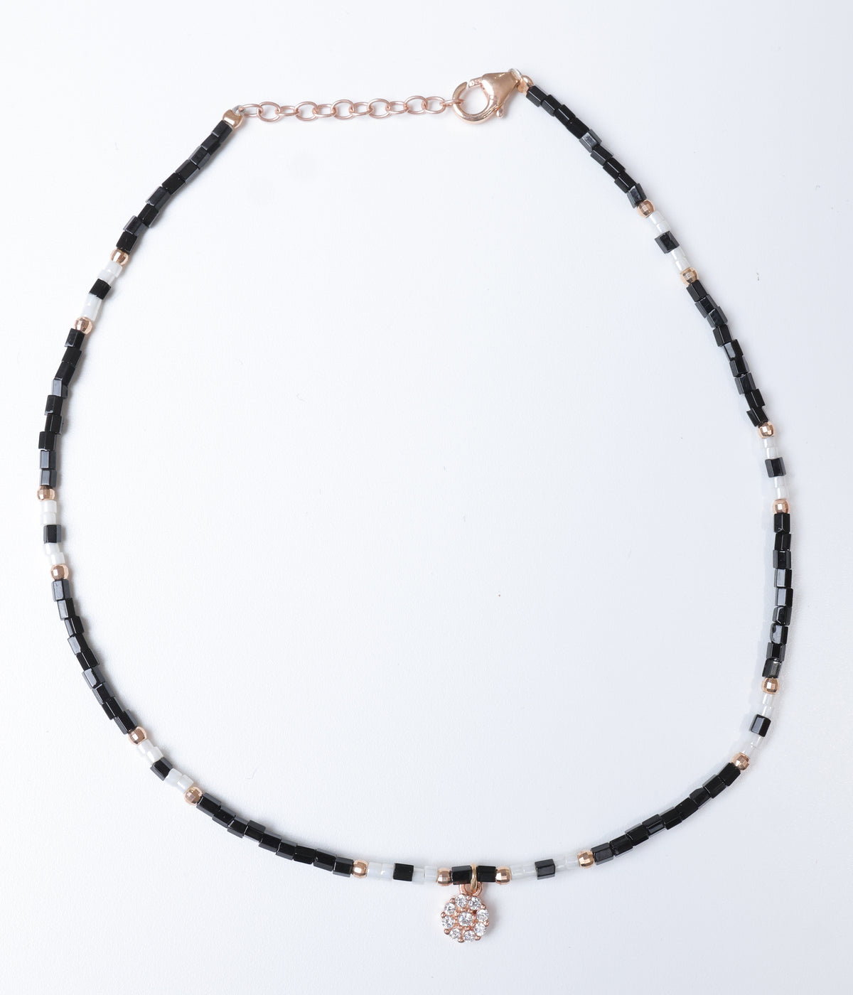 Black and white beaded anklet with rose gold-tone accents and a sparkling floral crystal charm.