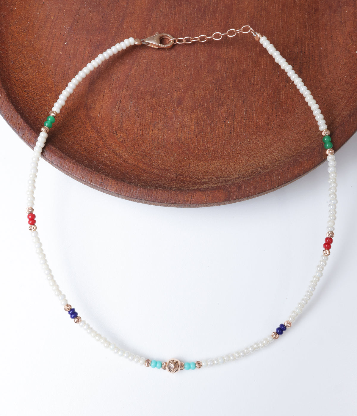 White pearl beaded anklet with multicolour green, red, blue and turquoise beads and rose gold-tone accents.