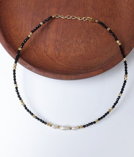 Black faceted bead anklet with white pearl accents and gold-tone decorative beads.