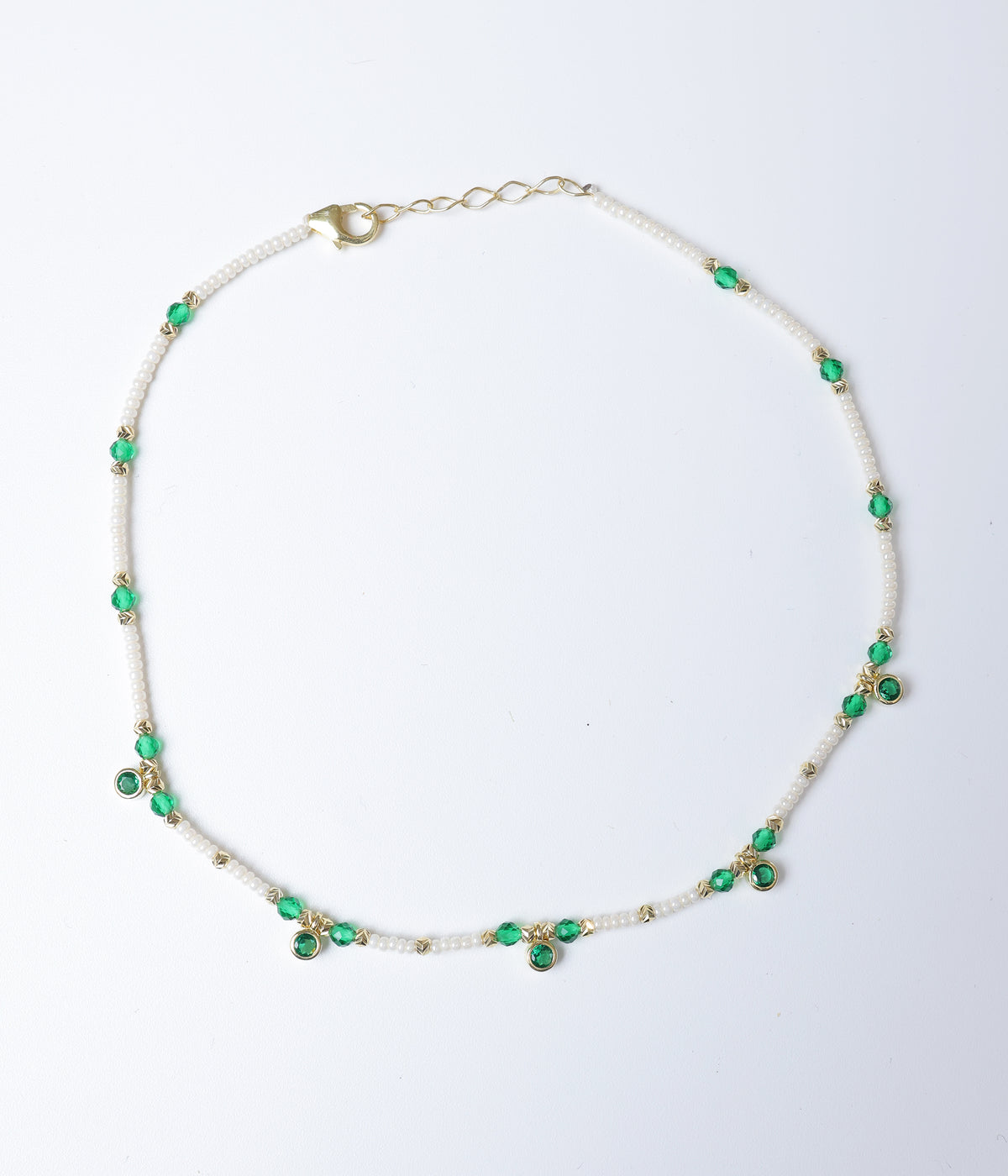 Green faceted stone and white pearl beaded anklet with gold-tone accents and green stone charms.